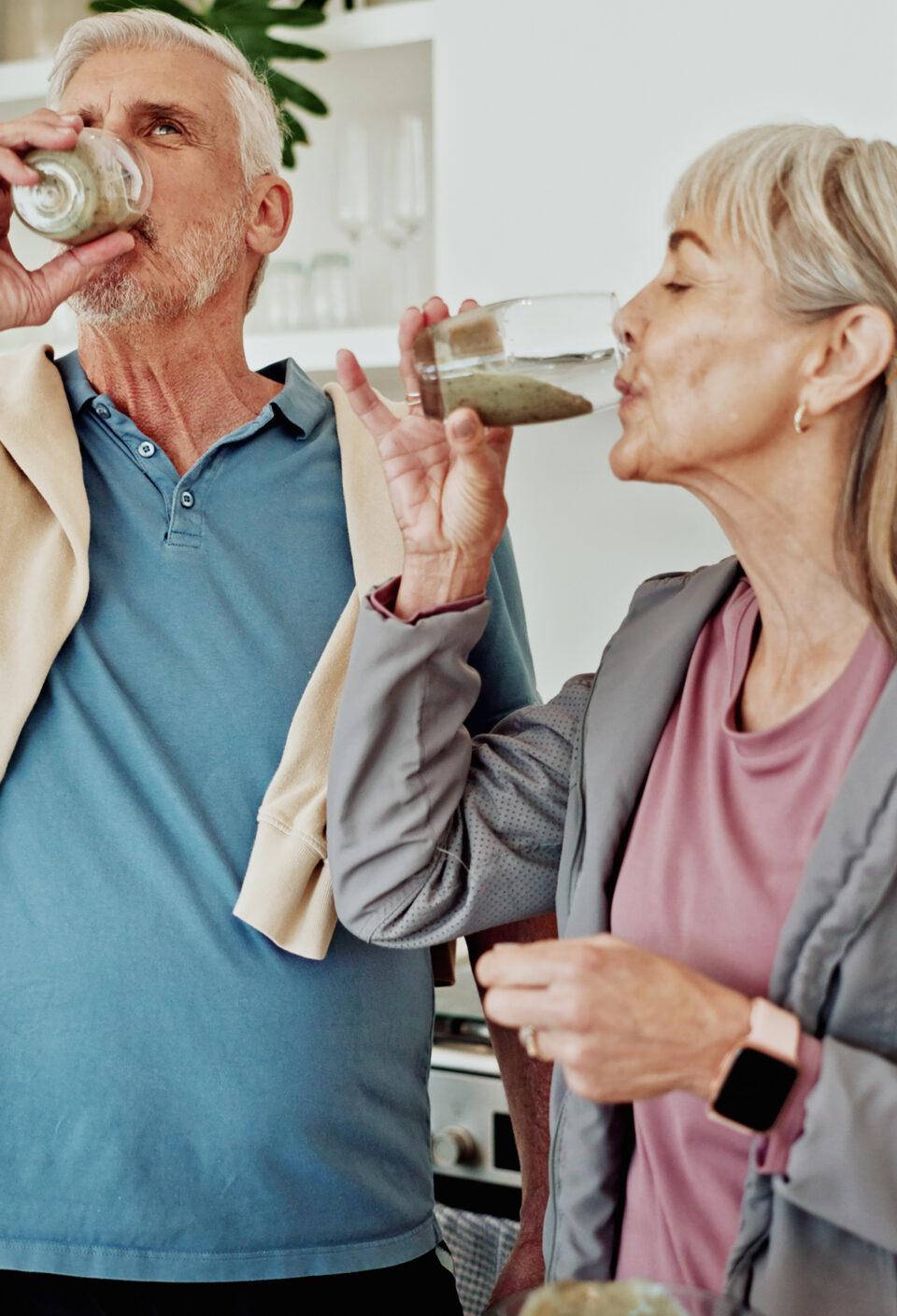 Exercise, drinking smoothie and old couple in kitchen for nutrition, breakfast and supplements. Fitness, mature man and woman in home, health and protein shake for wellness, diet plan and minerals